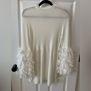 white ribbed knit sweater with layered petal -trim flare sleeves.